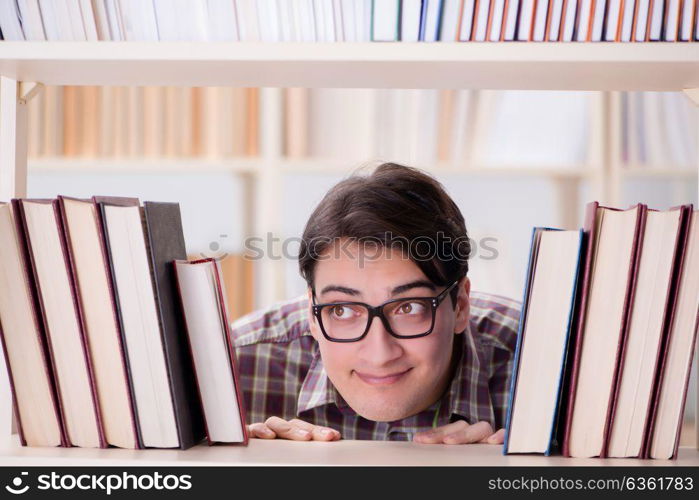 Young student looking for books in college library