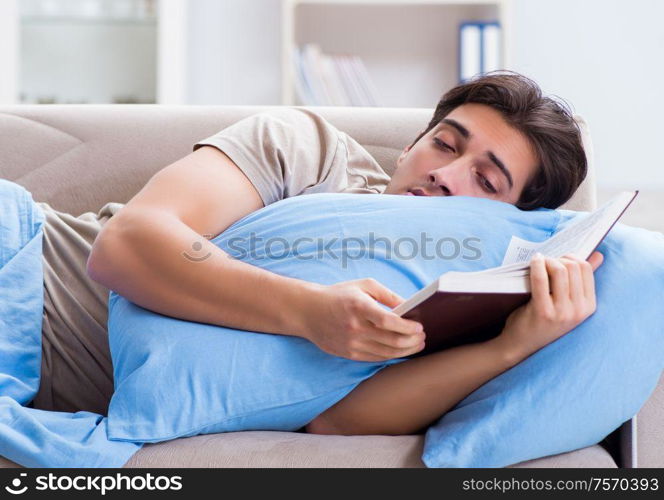 Young student man preparing for college exams in bed with book. The young student man preparing for college exams in bed with bo