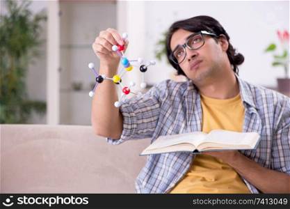 Young student physicist preparing for exam at home   . Young student physicist preparing for exam at home    