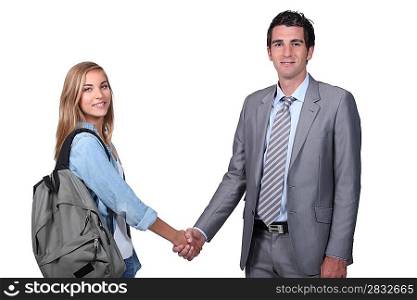 Young student shaking hands with a man in a suit