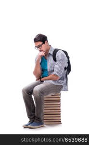 Young student sitting on top of book stack on white