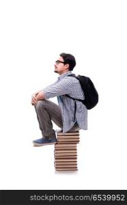 Young student sitting on top of book stack on white