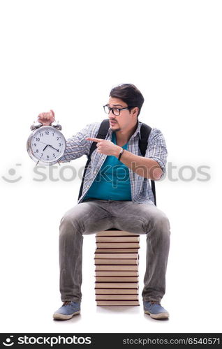 Young student sitting on top of book stack on white