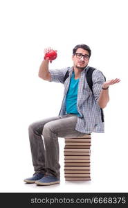 Young student sitting on top of book stack on white