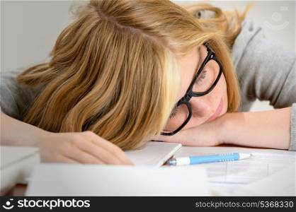 Young student teenager sleeping over her books tired of school
