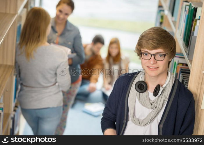 Young student with headphones with classmates in university library