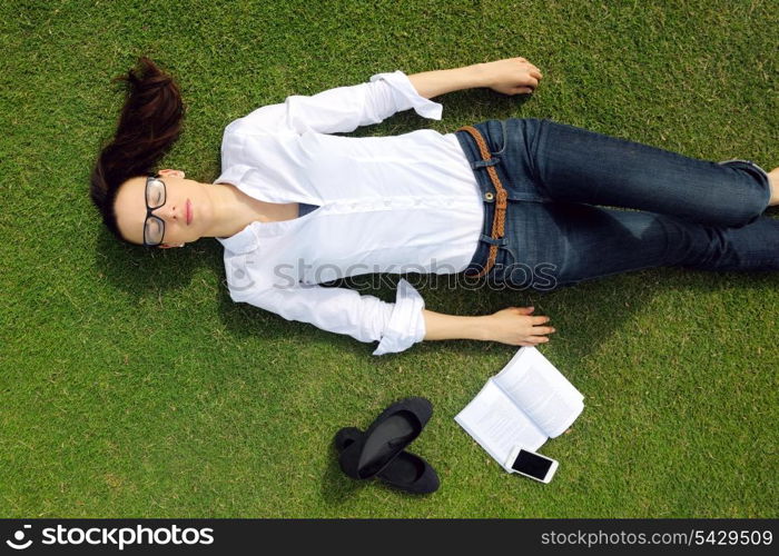 Young student woman reading a book and study in the park