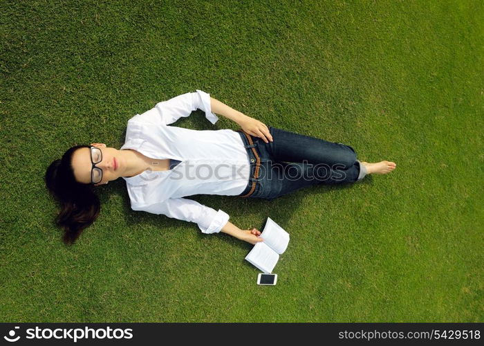 Young student woman reading a book and study in the park