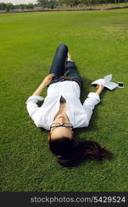 Young student woman reading a book and study in the park