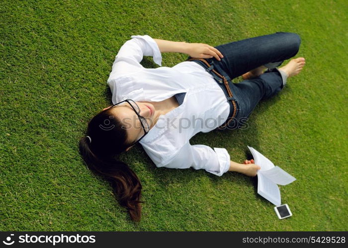 Young student woman reading a book and study in the park