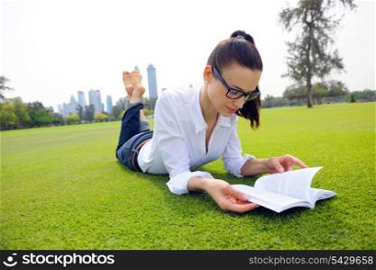 Young student woman reading a book and study in the park