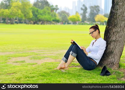 Young student woman reading a book and study in the park