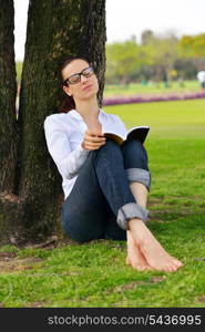 Young student woman reading a book and study in the park