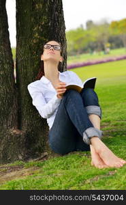 Young student woman reading a book and study in the park