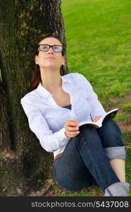 Young student woman reading a book and study in the park