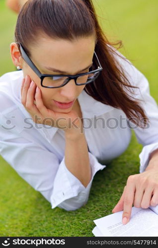 Young student woman reading a book and study in the park