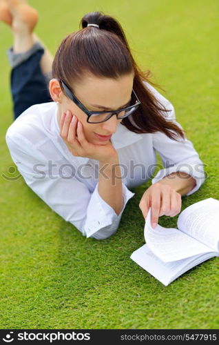 Young student woman reading a book and study in the park