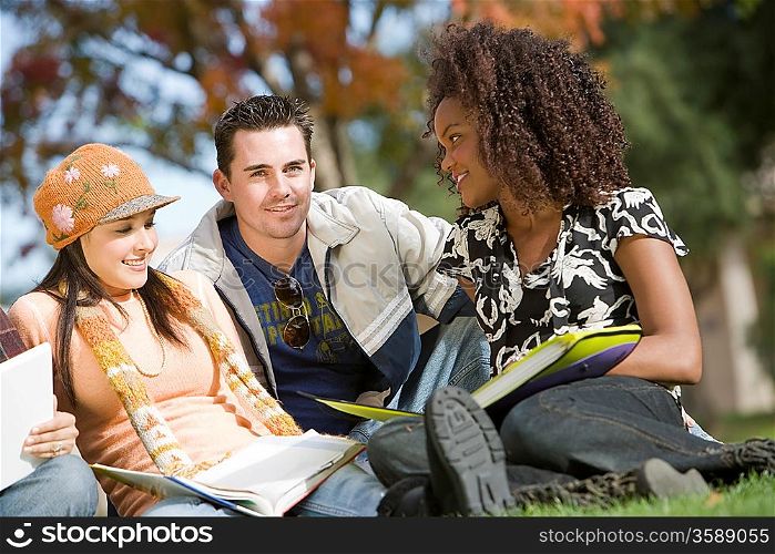 Young students sitting on grass