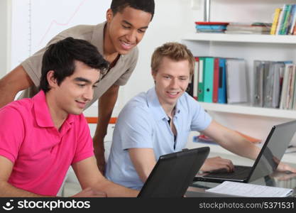 Young students working on their laptops in the university library