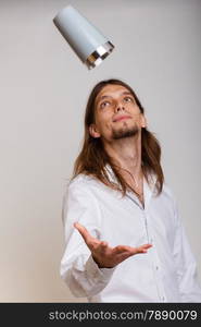 Young stylish man bartender making alcohol cocktail drink, trowing shaker into air studio shot on gray