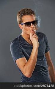 Young stylish man smoking a cigarette