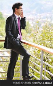 young successful business man talking on celphone outdoor on balcony