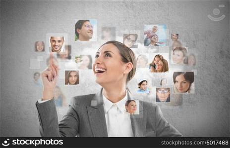 Young successful business woman looking at people portraits. International communication and recruitment concept