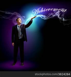 Young successful businessman holding a shining light in his hand as a symbol of success and advancement.