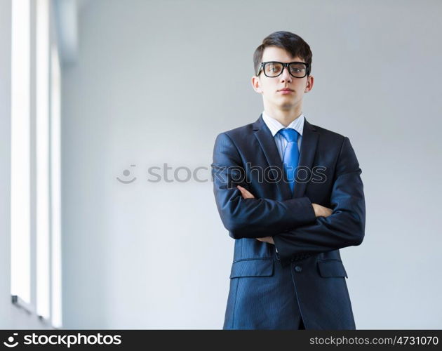 Young successful businessman. Image of handsome businessman in glasses with arms crossed on chest