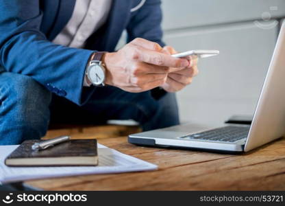 Young successful businessman typing a text on mobile phone. while sitting in cafe.