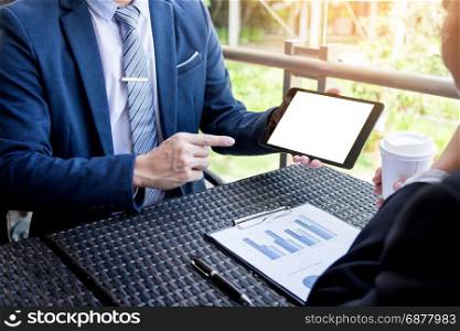 Young successful businessman using tablet for working in park outdoors.