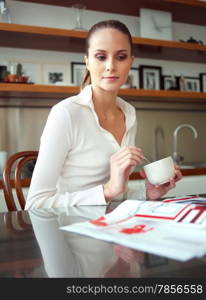 young successful woman, enjoying a cup of coffee in her home