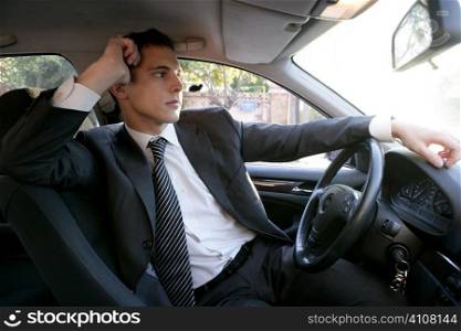 Young suit businessman posing inside his car