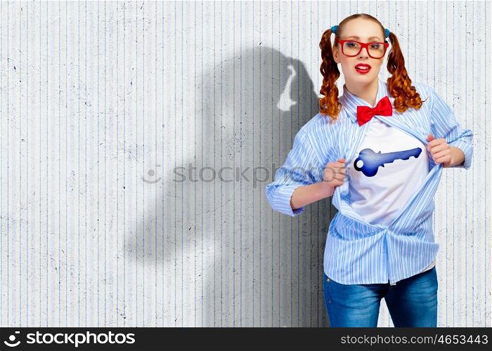 Young super hero woman. Young woman acting like super hero with key sign on chest