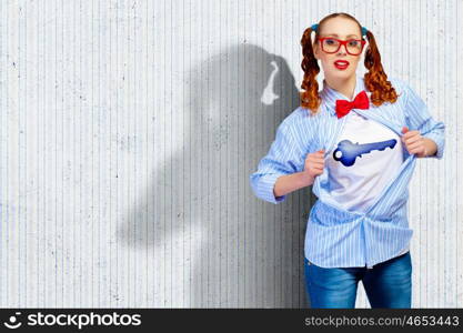 Young super hero woman. Young woman acting like super hero with key sign on chest