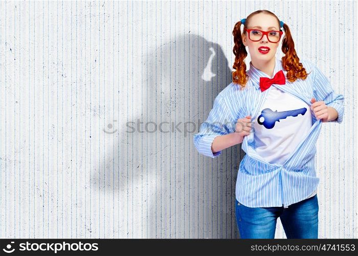 Young super hero woman. Young woman acting like super hero with key sign on chest