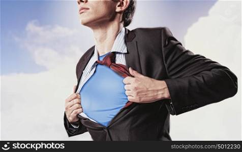 Young superhero businessman. Image of young businessman showing superhero suit underneath his shirt