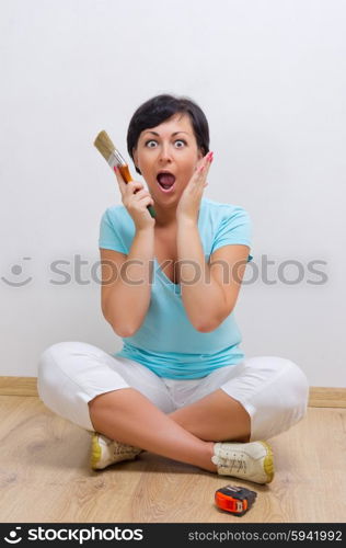 Young surprised woman with painting brush