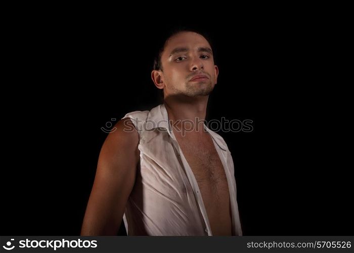 Young tanned man in a white shirt on a black background