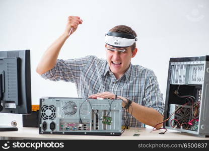 Young technician repairing computer in workshop