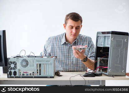 Young technician repairing computer in workshop