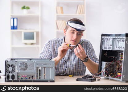 Young technician repairing computer in workshop