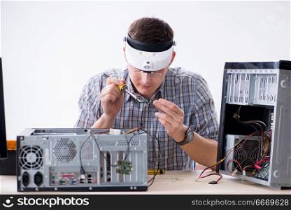 Young technician repairing computer in workshop