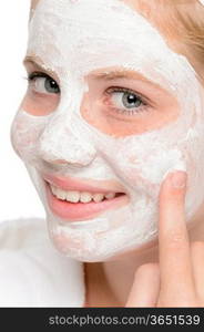 Young teen girl putting facial mask cream fingers smiling