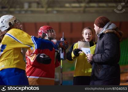 young teen, girls ice hockey players team group meeting with trainer in sport arena indoors