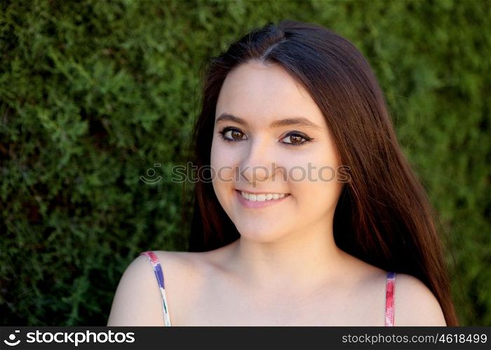 Young teen relaxed outdoors with a natural green background