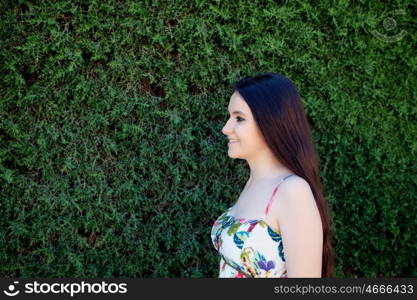 Young teen relaxed outdoors with a natural green background