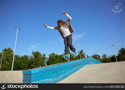 Young teen wearing inline skates doing balancing stunt at skateboard park. Extreme sports event for teenagers. Young teen wearing inline skates doing balancing stunt at skateboard park