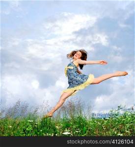Young teenage girl jumping in summer meadow amid wildflowers