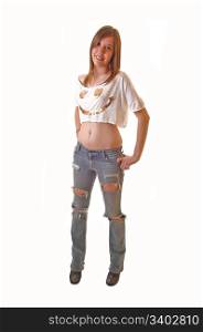 Young teenage girl standing in ripped jeans and a short t-shirt in thestudio, smiling, on white background.